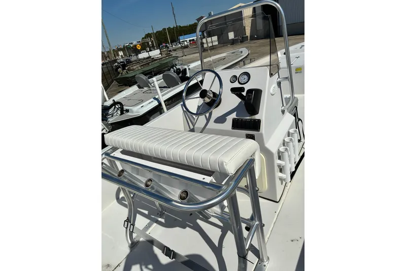 Slide: The Image of 2024 ALK2 Powerboats 21BHX console with steering wheel and seating, docked outdoors. - 5