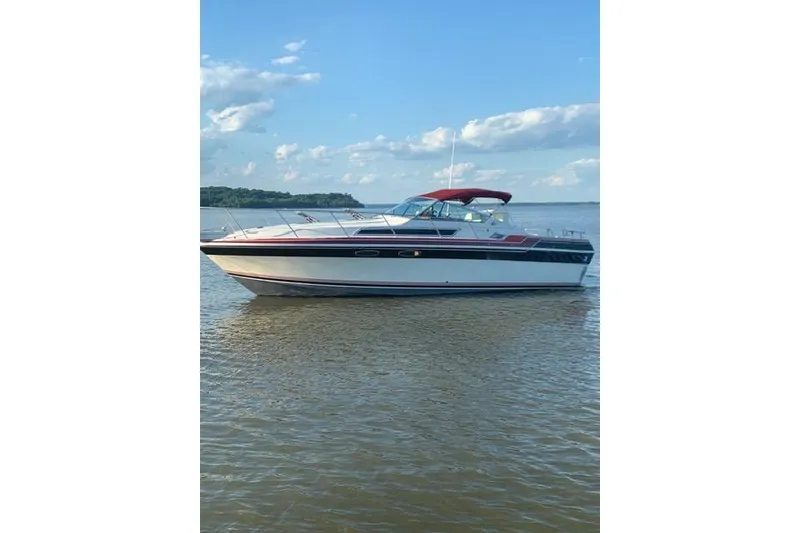 The Image of 1986 Wellcraft 3200 St. Tropez boat on calm water under a blue sky. - 0