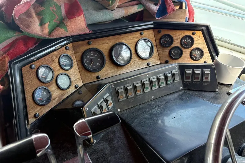 Slide: The Image of 1986 Wellcraft 3200 St. Tropez dashboard with gauges and switches, featuring a wooden panel. - 7
