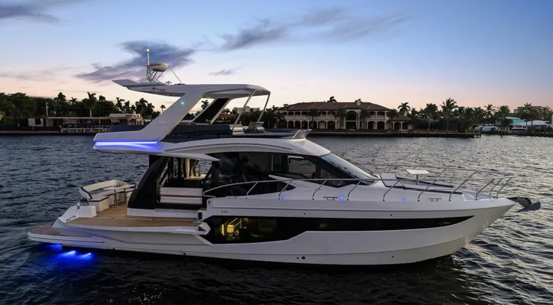 Slide: The Image of 2025 Galeon 500 Fly yacht cruising at sunset on a serene waterway. - 2
