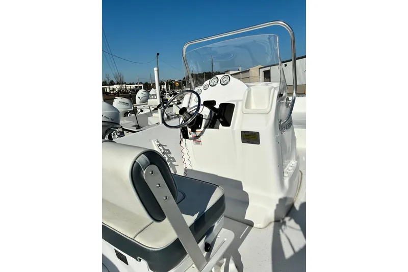 Slide: The Image of 2024 ALK2 Powerboats 22 CRS console with steering wheel and gauges under clear blue sky. - 3