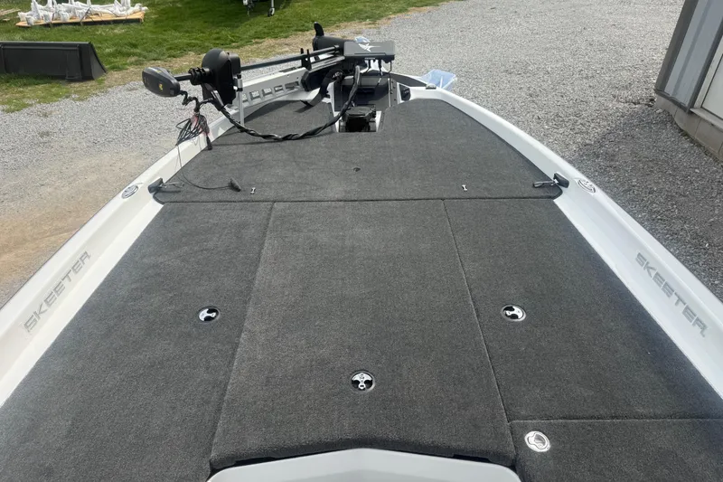 Slide: The Image of 2026 Skeeter ZXR21 SE boat deck with carpeted surface and fishing equipment. - 11