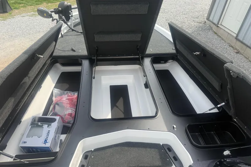 Slide: The Image of Open storage compartments in a 2026 Skeeter ZXR21 SE boat. - 12