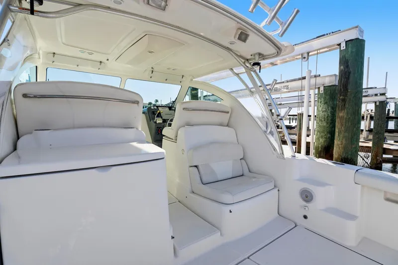 Slide: The Image of 2007 Tiara Yachts 3000 Open interior with white seating and helm, docked at marina. - 10