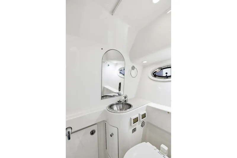 Slide: The Image of 2007 Tiara Yachts 3000 Open bathroom with sink, mirror, and porthole window. - 18