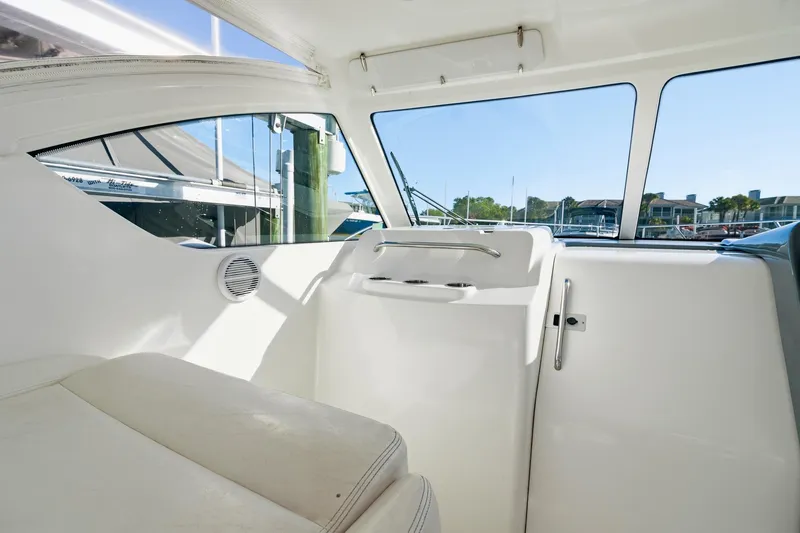 Slide: The Image of Interior view of a 2007 Tiara Yachts 3000 Open, showcasing sleek white seating and windows. - 9