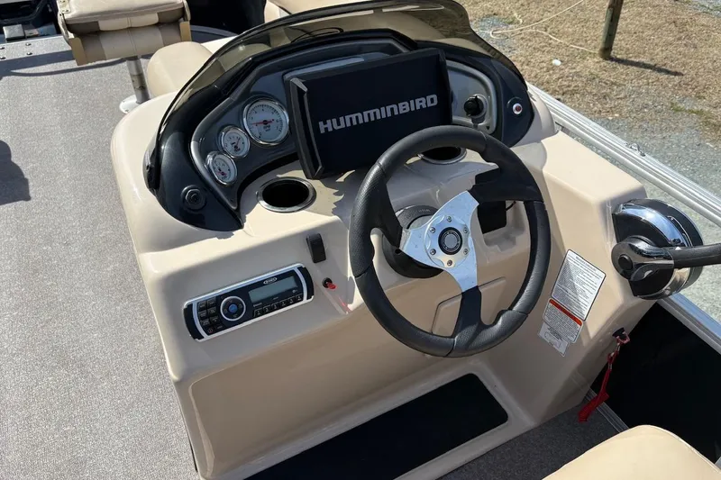 Slide: The Image of 2016 Sun Tracker Fishin' Barge 20 DLX dashboard with steering wheel and Humminbird display. - 10
