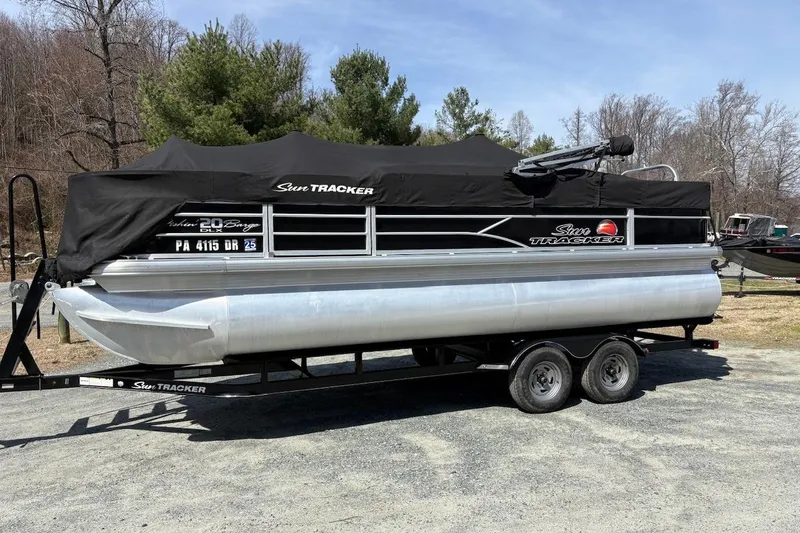 Slide: The Image of 2016 Sun Tracker Fishin' Barge 20 DLX pontoon boat on trailer, covered and parked outdoors. - 5