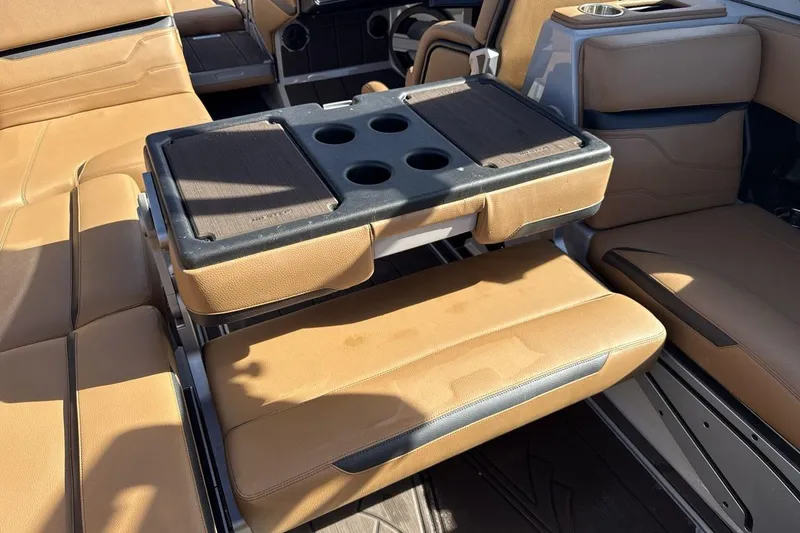 Slide: The Image of 2024 Supra SV interior with tan leather seats and a foldable table. - 23