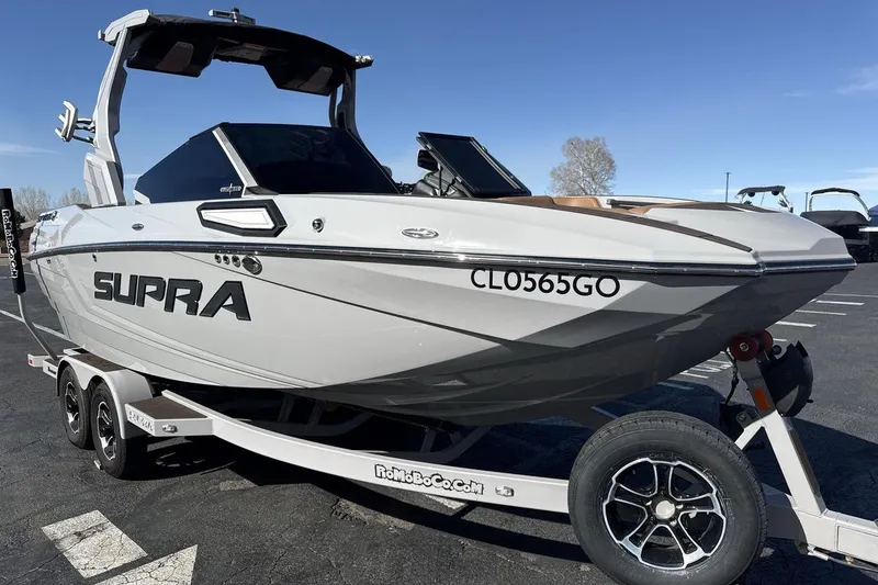Slide: The Image of 2024 Supra SV boat on trailer, sleek design, parked outdoors under clear sky. - 7
