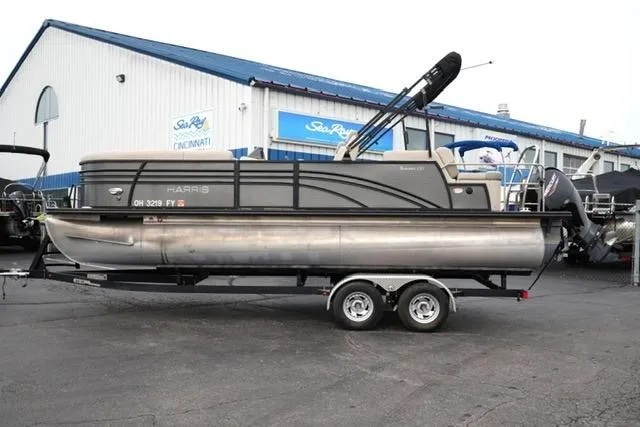 The Image of 2021 Harris Sunliner 230 pontoon boat on trailer outside dealership. - 1