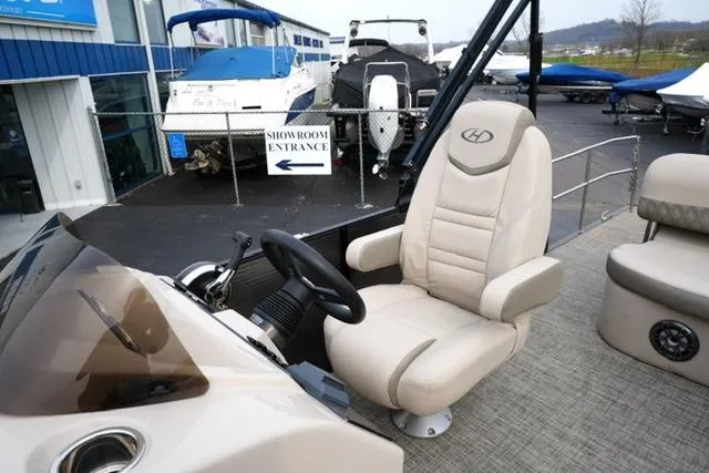Slide: The Image of 2021 Harris Sunliner 230 boat interior with captain's chair and steering wheel. - 11