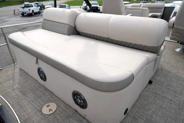 Slide: The Image of 2021 Harris Sunliner 230 boat interior with beige seating and integrated speakers. - 15