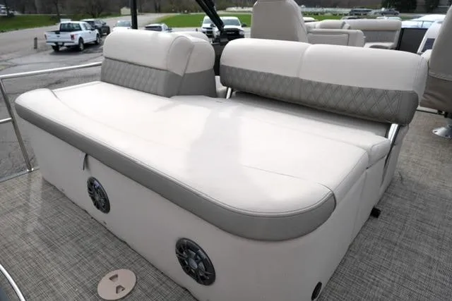 Slide: The Image of 2021 Harris Sunliner 230 boat interior with beige seating and built-in speakers. - 16