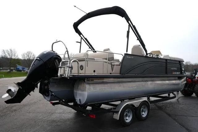 Slide: The Image of 2021 Harris Sunliner 230 pontoon boat on trailer, featuring sleek design and powerful outboard motor. - 5