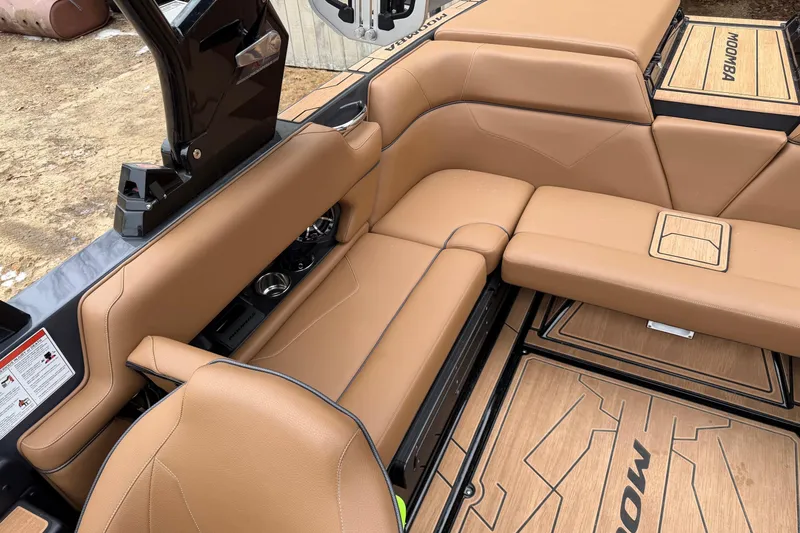 Slide: The Image of 2022 Moomba Kaiyen boat interior with tan leather seating and wood accents. - 21