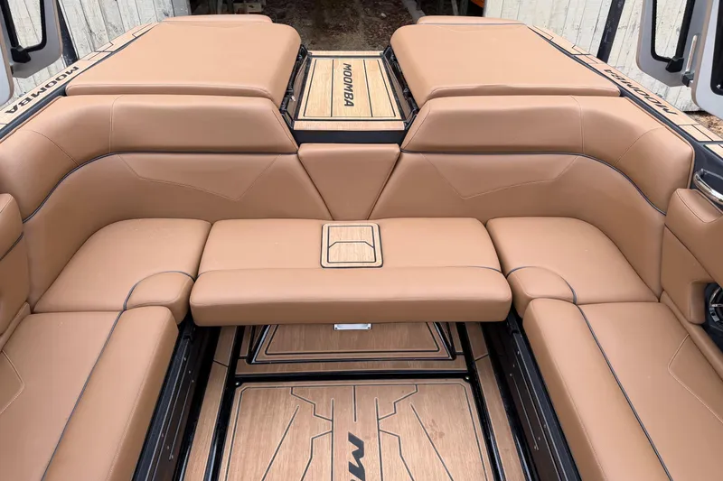 Slide: The Image of 2022 Moomba Kaiyen boat interior with tan leather seating and wood accents. - 22