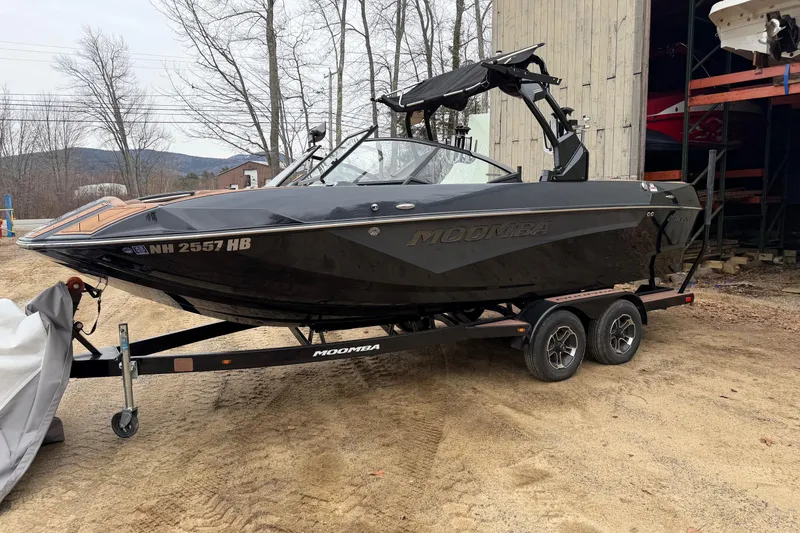 Slide: The Image of 2022 Moomba Kaiyen boat on trailer, parked outdoors near trees and a building. - 24