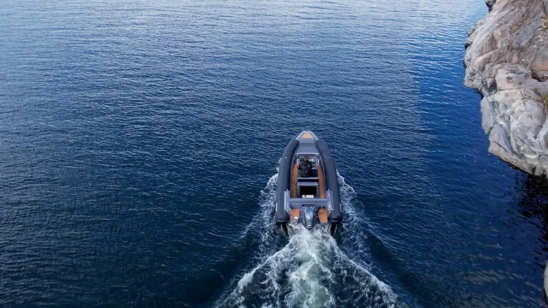 Slide: The Image of 2024 Northstar Orion 6 boat cruising on open water near rocky shoreline. - 4