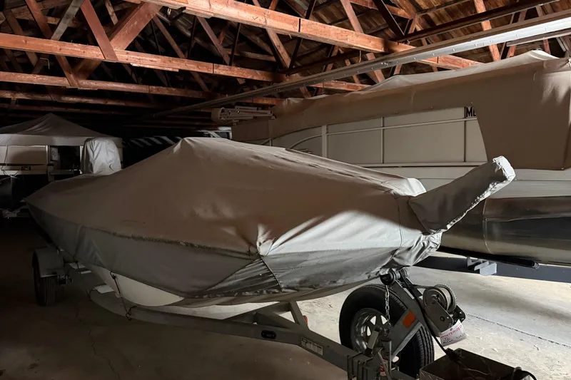 Slide: The Image of Covered 2009 G3 1860 CC Deluxe boat stored in a wooden-roofed garage. - 5