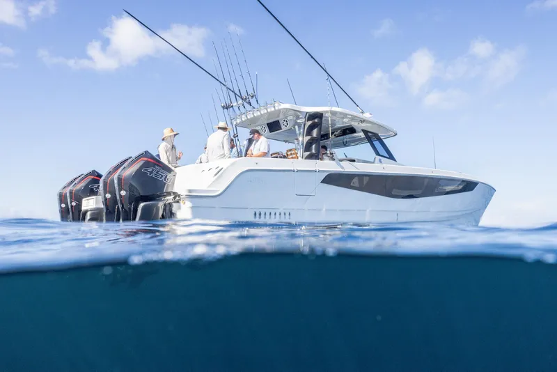 Slide: The Image of 2024 Aquila 47 Molokai boat on water, featuring multiple outboard engines and fishing rods. - 3