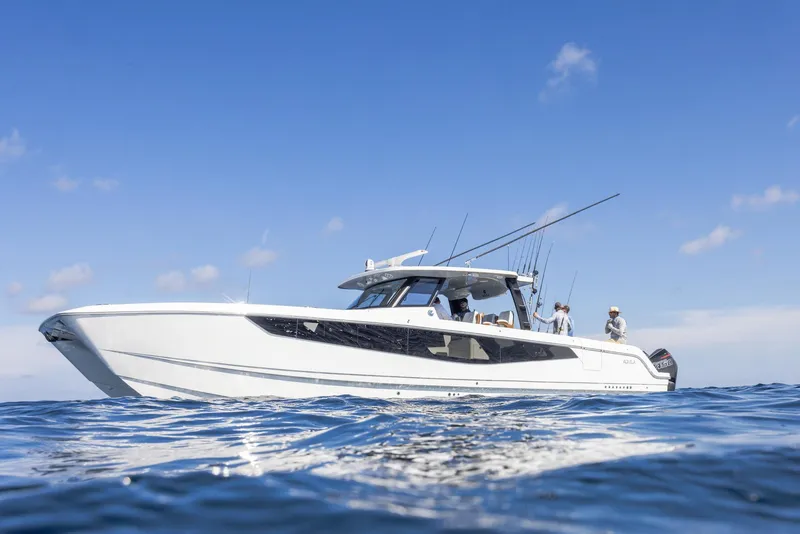 Slide: The Image of 2024 Aquila 47 Molokai boat cruising on open water under clear blue sky. - 4
