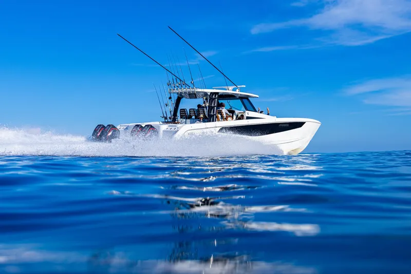Slide: The Image of 2024 Aquila 47 Molokai powerboat cruising on open water under clear blue skies. - 6