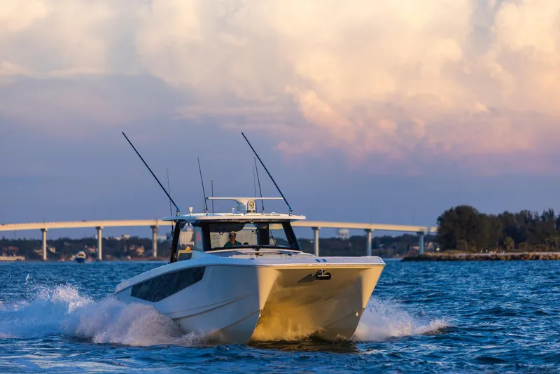 Slide: The Image of 2024 Aquila 47 Molokai cruising on water with scenic bridge and sky backdrop. - 8