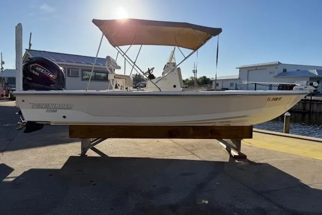 Slide: The Image of 2016 Pathfinder 2200 TRS boat with canopy, docked under sunlight. - 2