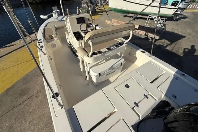 Slide: The Image of 2016 Pathfinder 2200 TRS boat interior with seating and storage compartments at a dock. - 7