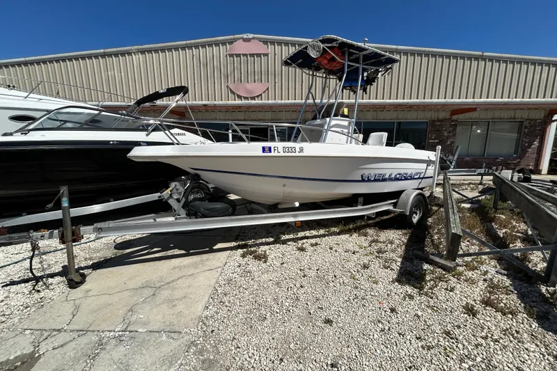 The Image of 1996 Wellcraft 190 CCF boat on trailer, parked outside a warehouse. - 0