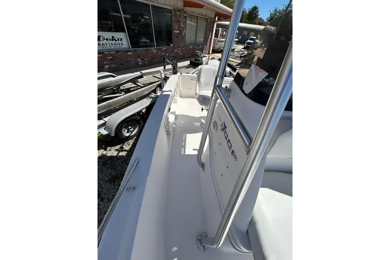 Slide: The Image of 1996 Wellcraft 190 CCF boat interior with seating and railing, parked near a building. - 6