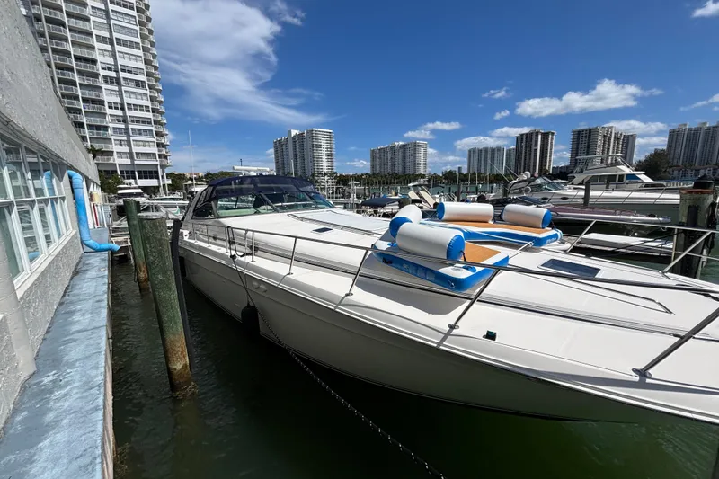 Slide: The Image of 1998 Sea Ray 500 Sundancer yacht docked in a marina with city skyline. - 1