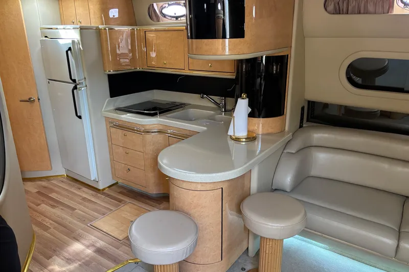 Slide: The Image of 1998 Sea Ray 500 Sundancer interior with kitchen, seating, and modern amenities. - 12