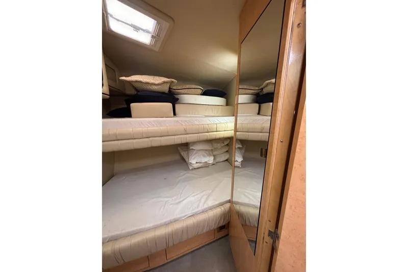 Slide: The Image of 1998 Sea Ray 500 Sundancer cabin with bunk beds and storage. - 21