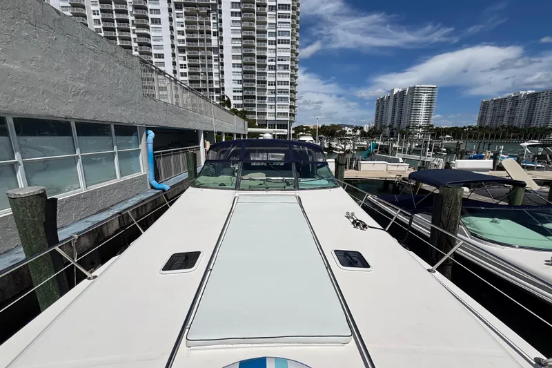 Slide: The Image of 1998 Sea Ray 500 Sundancer yacht docked at marina with high-rise buildings in background. - 25