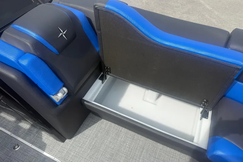Slide: The Image of 2026 Berkshire 25RFX DC STS boat seat with blue accents and open storage compartment. - 11