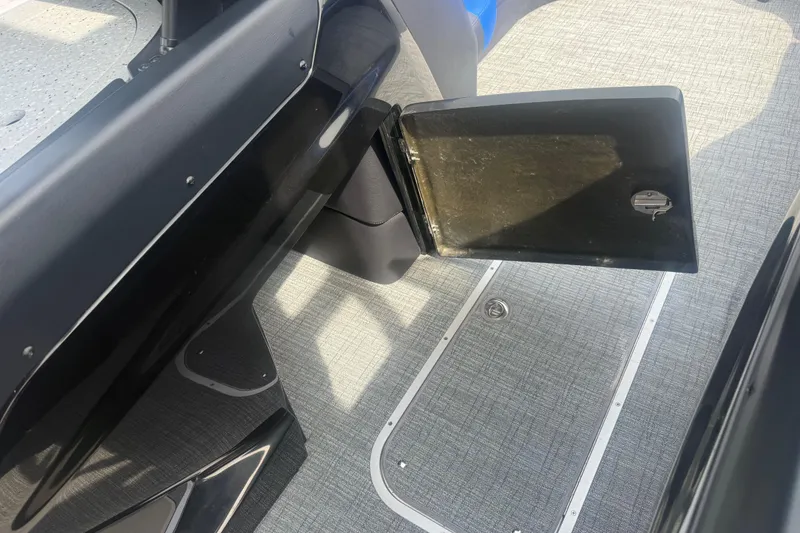 Slide: The Image of 2026 Berkshire 25RFX DC STS boat interior with open storage compartment and textured flooring. - 14