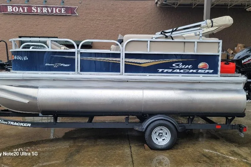 The Image of 2025 Sun Tracker Bass Buggy 16 XL pontoon boat on trailer at boat service center. - 1