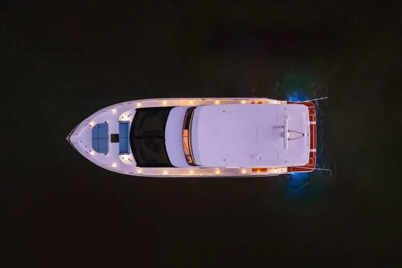 Slide: The Image of Aerial view of 2026 Cruisers Yachts 50 Fly illuminated on water at night. - 12