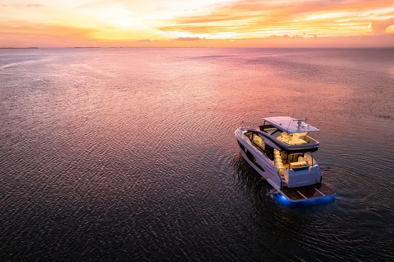 Slide: The Image of 2026 Cruisers Yachts 50 Fly at sunset on tranquil waters. - 15