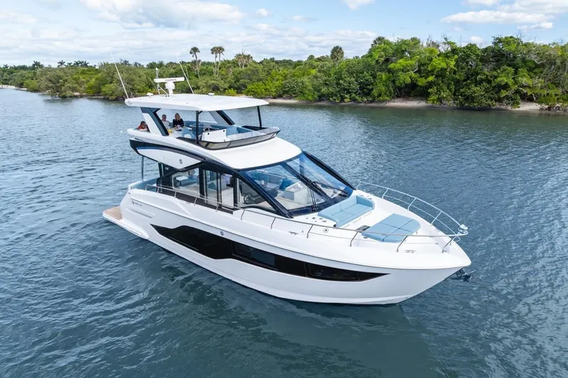 Slide: The Image of 2026 Cruisers Yachts 50 Fly luxury yacht cruising on a serene waterway. - 16