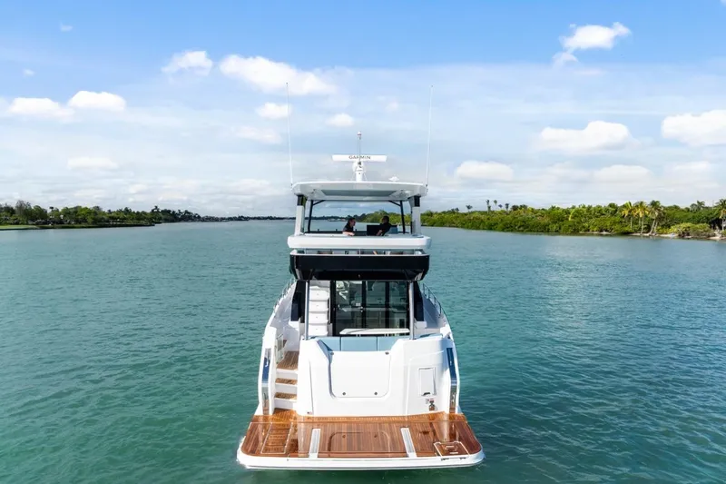 Slide: The Image of 2026 Cruisers Yachts 50 Fly on serene waterway, showcasing sleek design and luxury. - 22