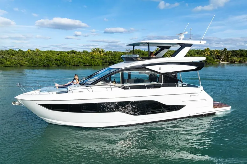 Slide: The Image of 2026 Cruisers Yachts 50 Fly luxury yacht cruising on a serene waterway. - 26