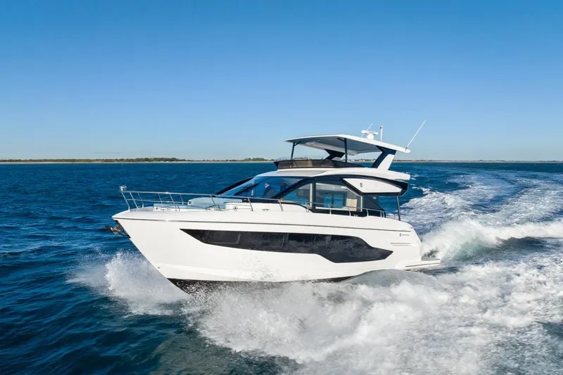 Slide: The Image of 2026 Cruisers Yachts 50 Fly cruising on open water under clear blue skies. - 35