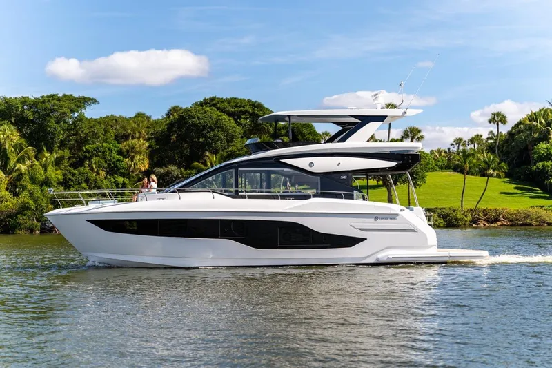 Slide: The Image of 2026 Cruisers Yachts 50 Fly luxury yacht cruising on a scenic waterway. - 44