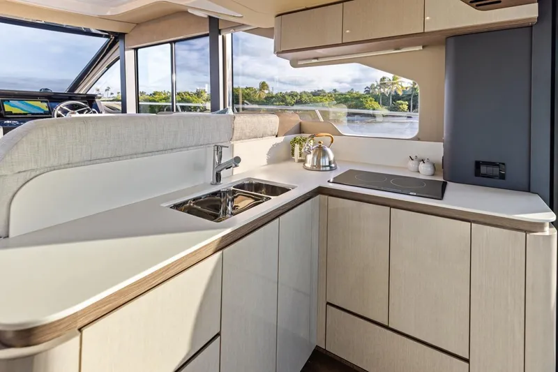 Slide: The Image of Modern kitchen interior on 2026 Cruisers Yachts 50 Fly, featuring sleek cabinetry and appliances. - 51