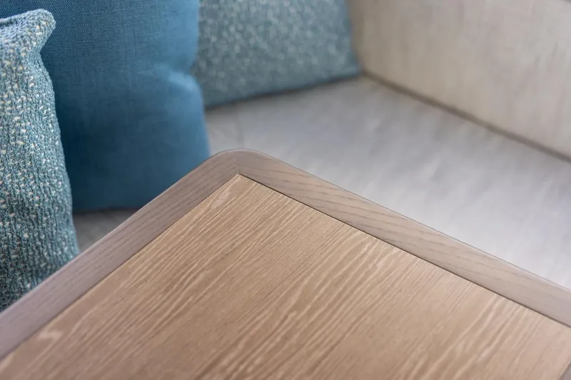 Slide: The Image of Luxurious interior detail of 2026 Cruisers Yachts 50 Fly with wooden table and blue cushions. - 74