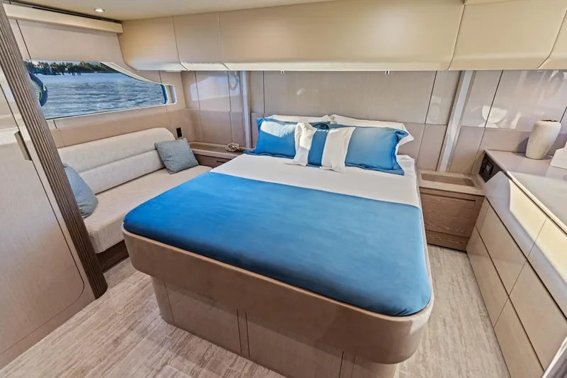 Slide: The Image of Luxurious bedroom interior of 2026 Cruisers Yachts 50 Fly with blue accents and scenic window view. - 75