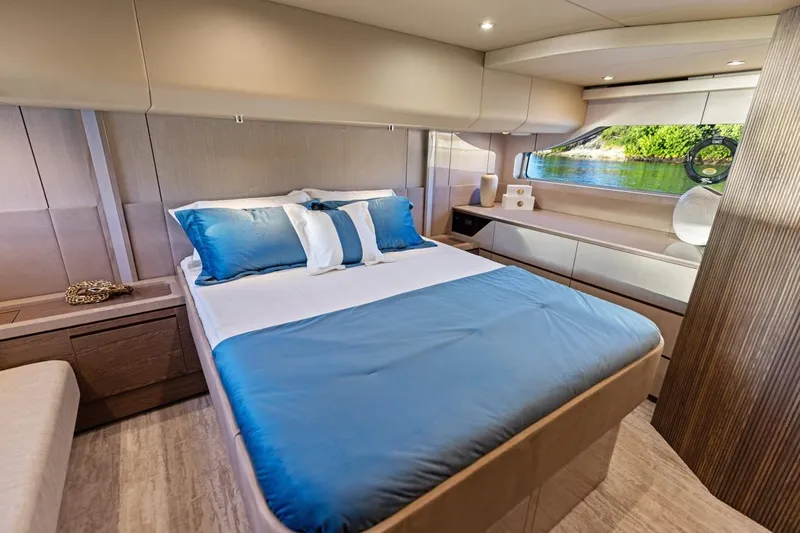 Slide: The Image of Luxurious bedroom interior of 2026 Cruisers Yachts 50 Fly with elegant blue bedding. - 76